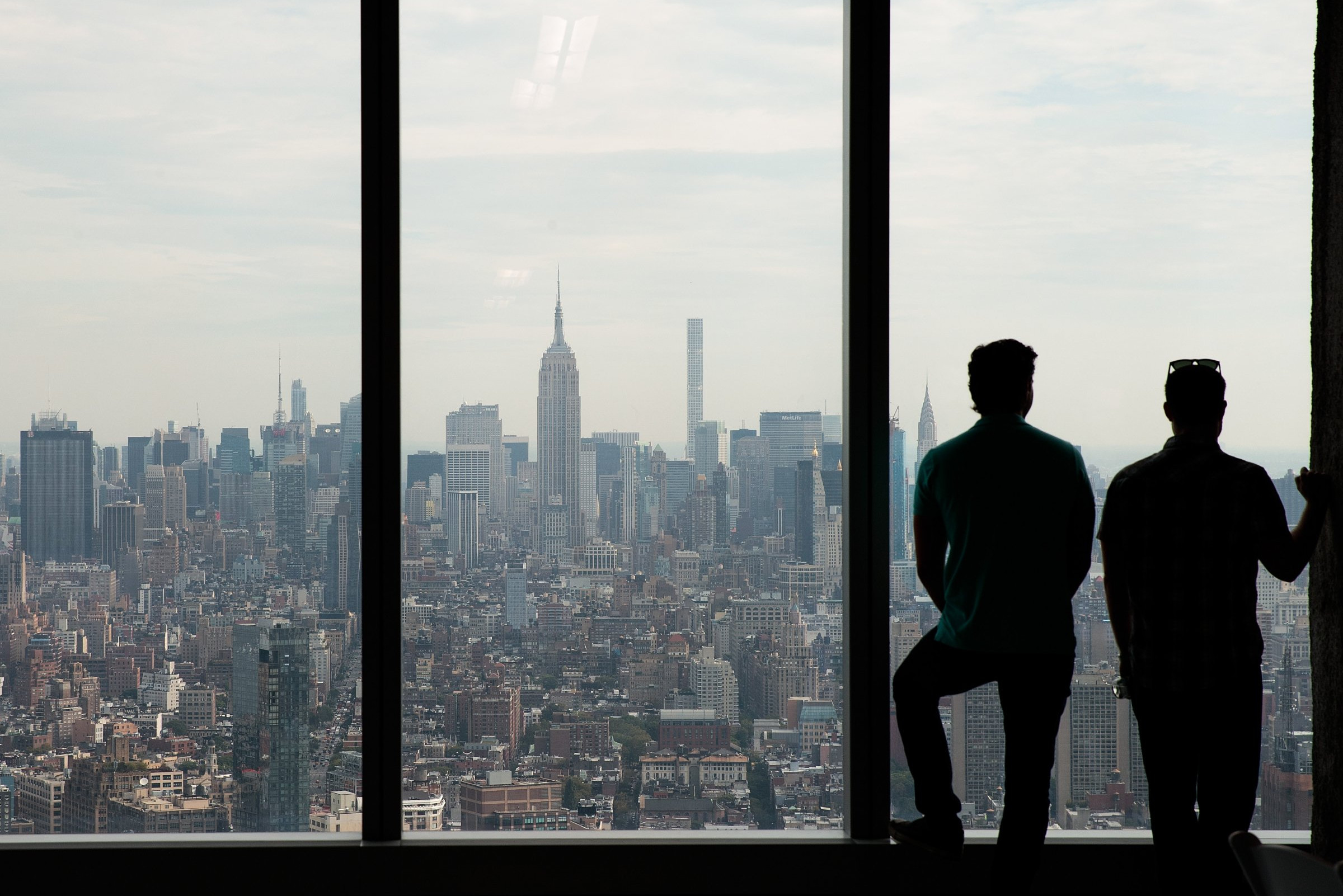 Dvojica radnika na Njujorškoj berzi posmatraju Njujork kroz prozor (Foto: Drew Angerer/Getty Images)