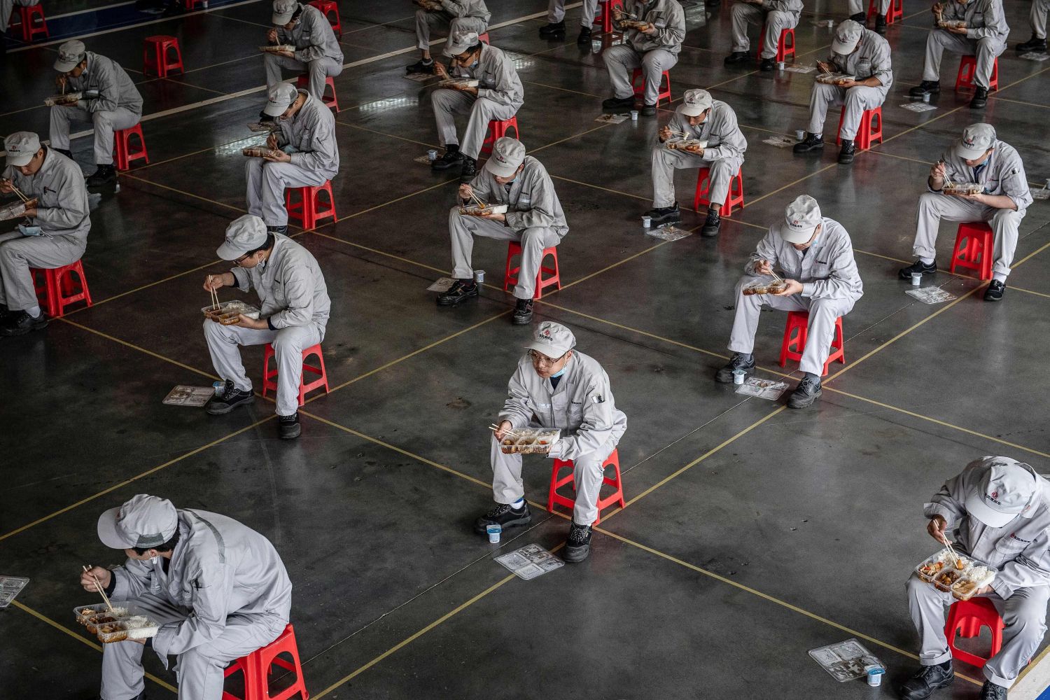 Radnici u fabrici automobila u Vuhanu drže distancu tokom pauze za obrok, 23. mart 2020. (Foto: STR/AFP/Getty Images)