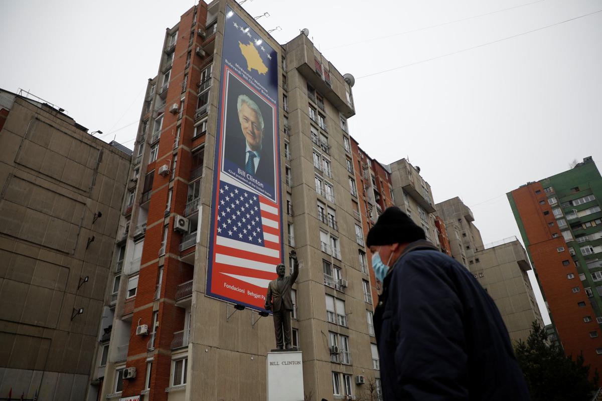 Čovek prolazi pored spomenika bivšem američkom predsedniku Bilu Klintonu, Priština, 20. decembar 2020. (Foto: Reuters/Florion Goga)